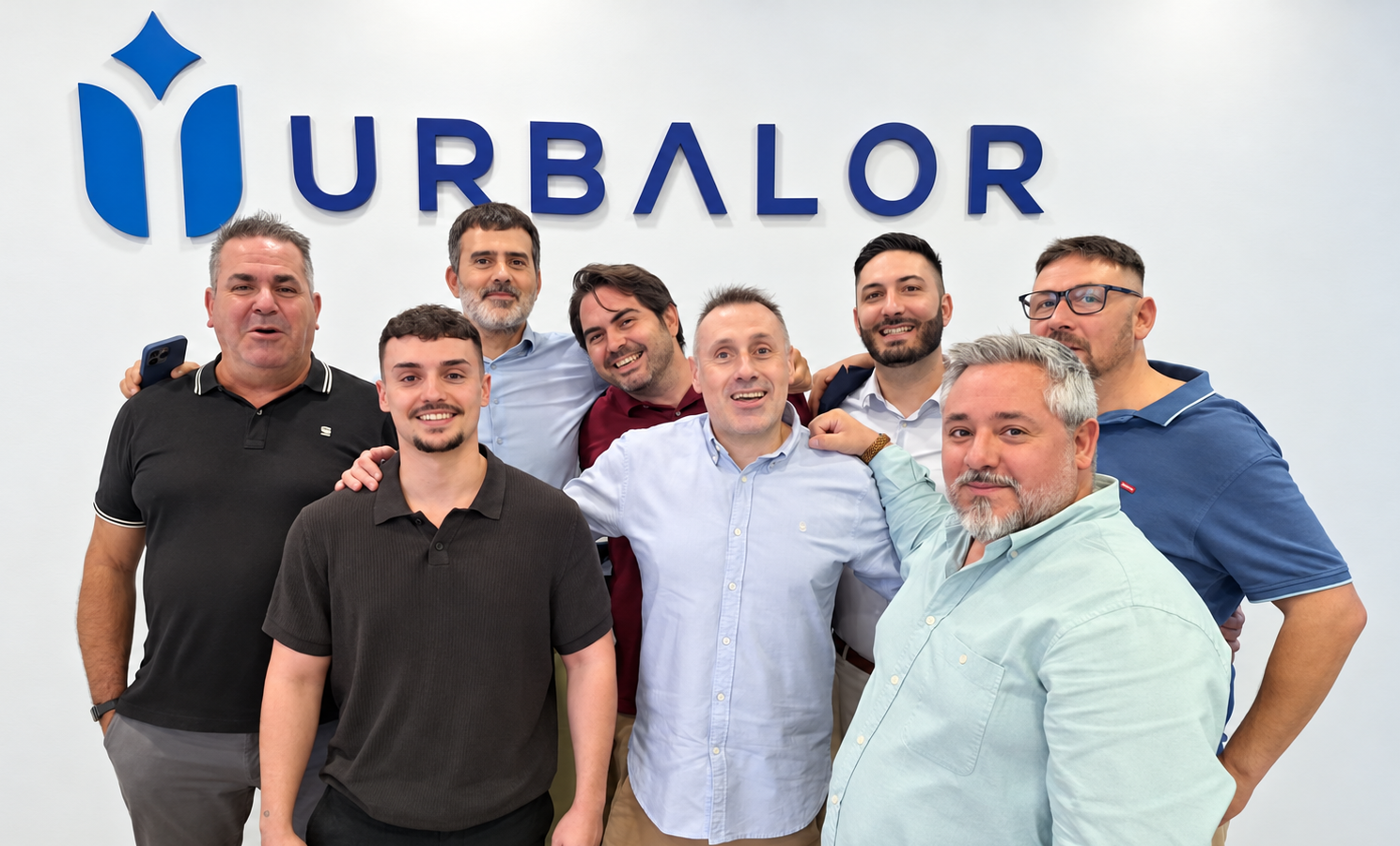 Equipo de Urbalor frente al logotipo de la empresa